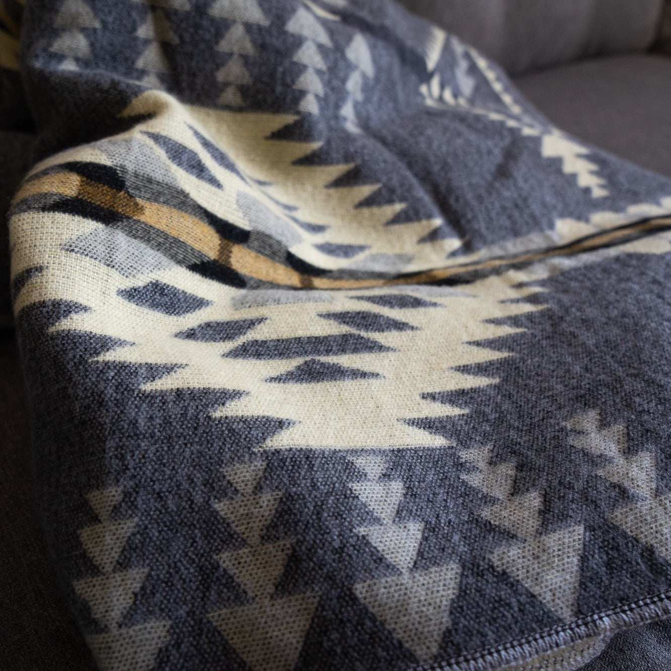Andean Alpaca Wool Blanket with vibrant patterns on a sofa.