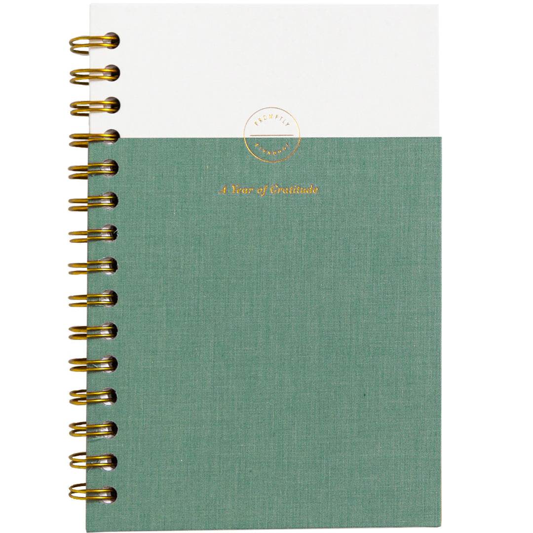 Gratitude Journal in sea foam green with linen cover and gold spiral binding by Promptly Journals.