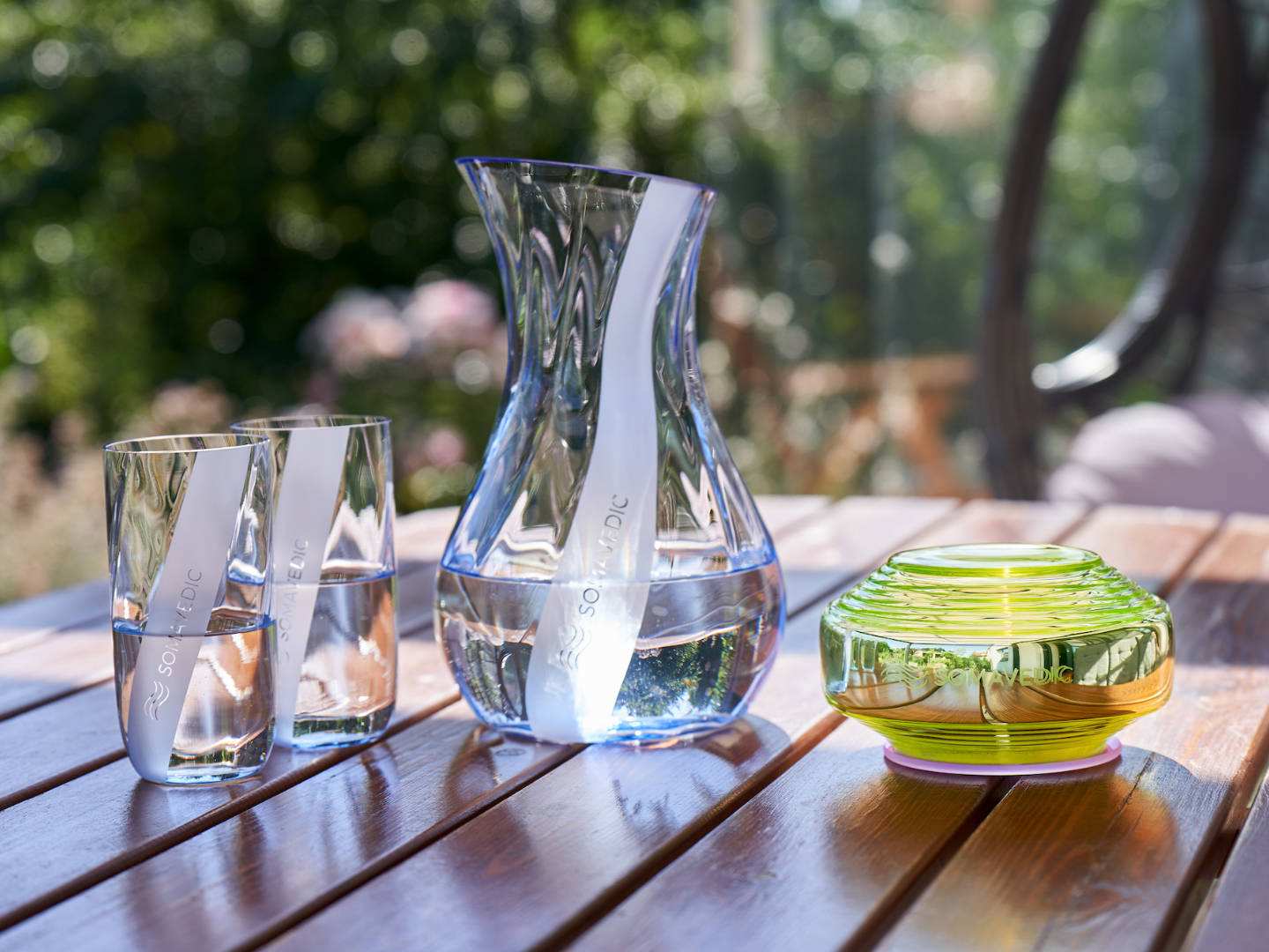 VEDIC Somatic Solution with glasses on outdoor table, advanced space harmonizer for Somavedic USA.