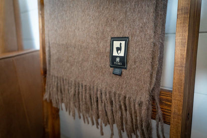 Alpaca wool throw blanket with fringe in solid brown color.