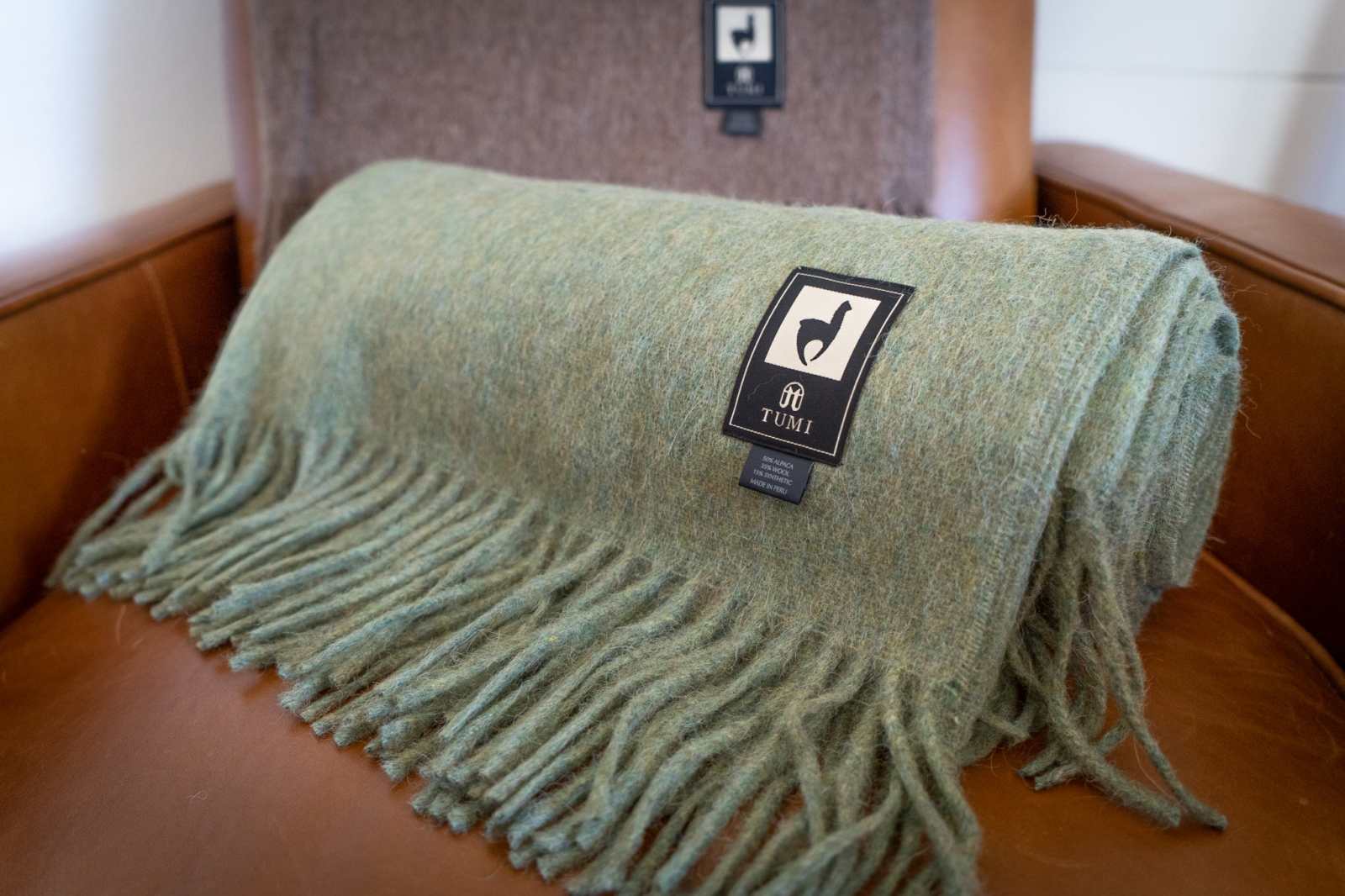 Alpaca wool throw blanket in green with fringe, perfect for cozy evenings.