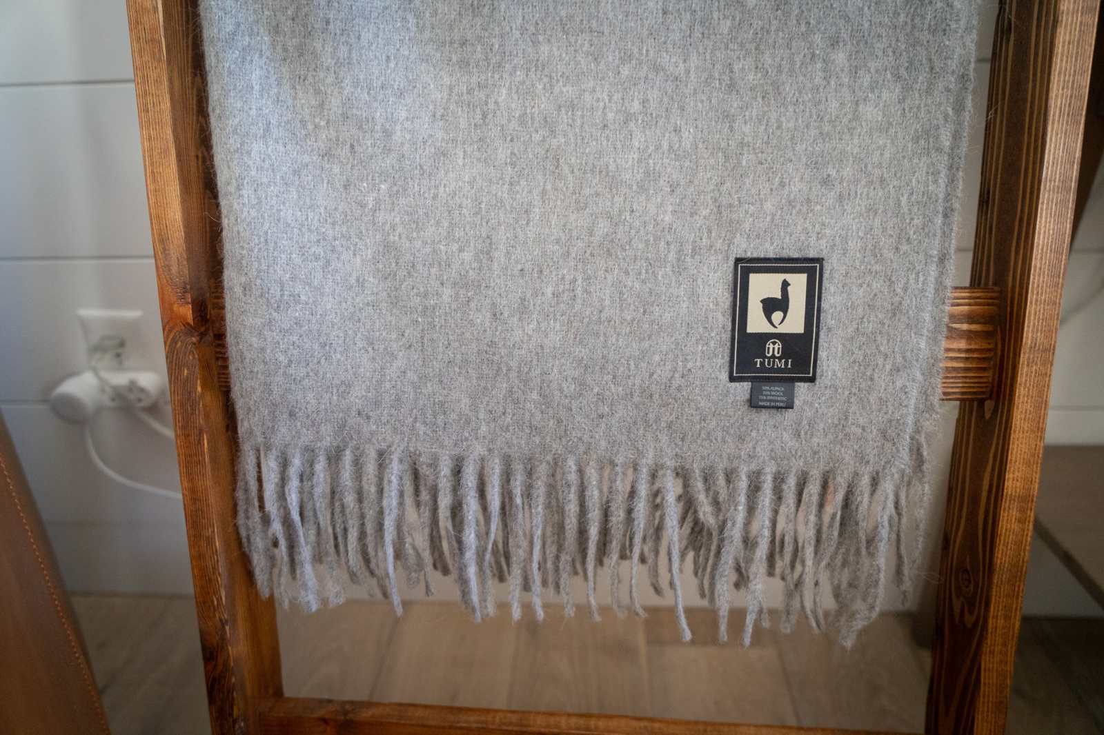 Light gray alpaca wool throw blanket with fringe, perfect for cozy evenings.