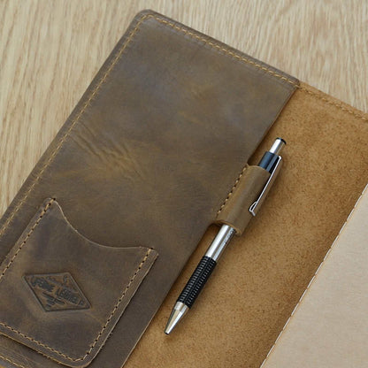 Handcrafted leather journal with pockets and pen holder, featuring burnished edges and a professional design.