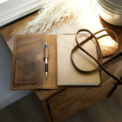 Handcrafted full-grain leather journal with pockets and card sleeve, includes a lined kraft paper journal.