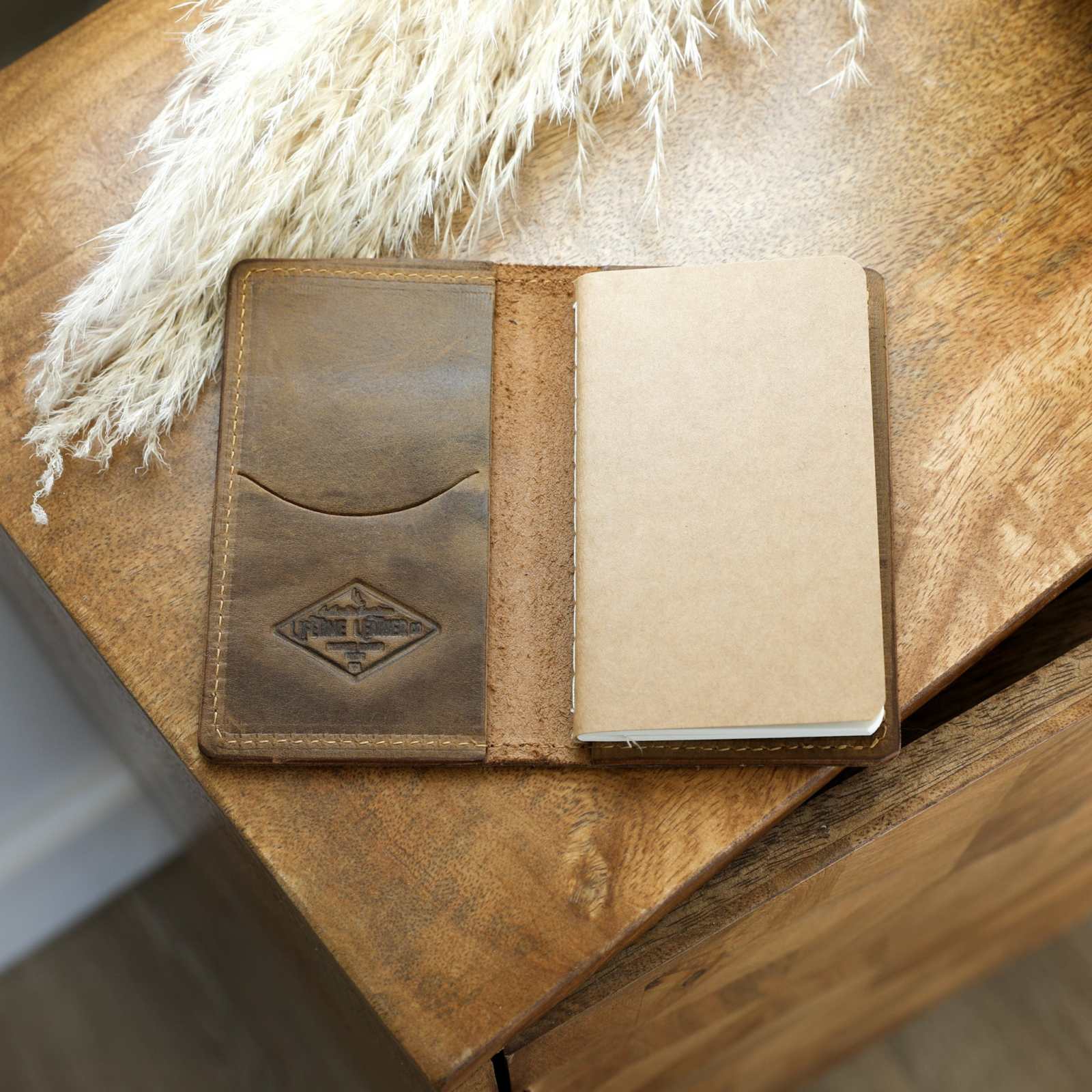 Handcrafted full-grain leather mini journal with card slot and lined paper refill.