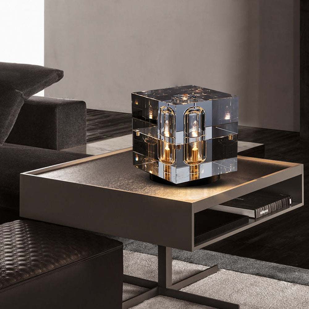 Contemporary crystal bedside table lamp with brass base on modern side table in elegant living room setting.