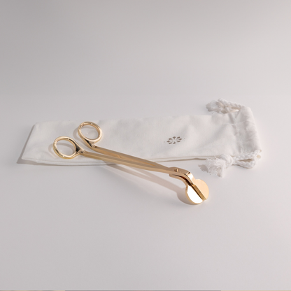 Candle snuffer and wick trimmer duo on white background with elegant pouch, essential for candle care.