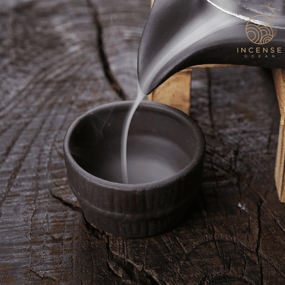 Mystical waterfall incense burner with cascading smoke effect on a wooden base.